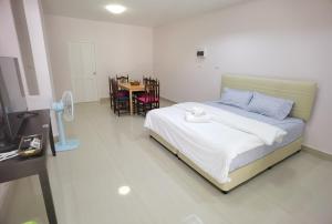 a bedroom with a bed and a table with chairs at TAcozy693 in Hat Yai