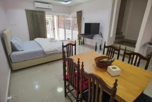 a living room with a dining table and a bedroom at TAcozy693 in Hat Yai