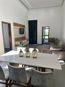 a living room with a table with three vases on it at Mini Palacete in Ribeirão Preto