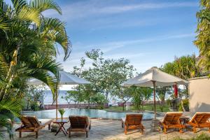 a group of chairs and an umbrella next to a pool at Villa Sky Dancer - Bali in Amed