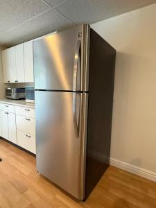 a stainless steel refrigerator in a kitchen at Suite and Simple in Ucluelet +18 photos