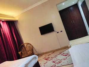 a room with a bed and a window and a tv at Arabesque Hotel in Cairo