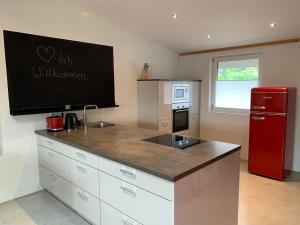 eine Küche mit einem roten Kühlschrank und einer Arbeitsplatte in der Unterkunft Chiemgau Loft in Bad Endorf