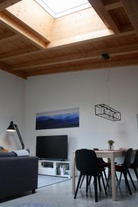 ein Wohnzimmer mit einem Tisch und einem Fernseher in der Unterkunft Chiemgau Loft in Bad Endorf