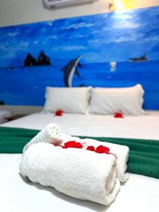 a hotel room with two beds with red roses on them at Pousada São Silmares in Fernando de Noronha