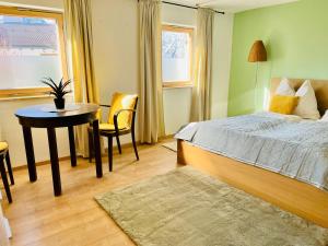 a bedroom with a bed and a desk and a table at Stille Auszeit in Zams