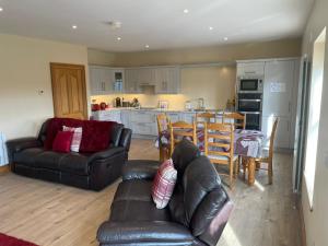 a living room with a couch and a table and a kitchen at Molly's Self Catering Accommodation in Cavan