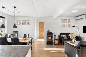 a living room with a fireplace and a table and chairs at 347-Harboore-Slettevej-71 in Harboør