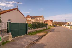 an empty street with houses and a green fence at Cocon des dunes in Camiers
