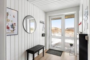 a room with a table and a mirror and a door at 347-Harboore-Slettevej-71 in Harboør