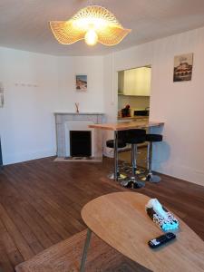a living room with a table and a fireplace at Appartement Refait a neuf avec accès au jardin , local vélo et Wifi in La Machine