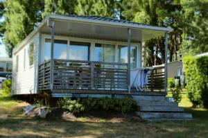 a tiny house with a porch and stairs at Camping Paradis les Capucines in Trédrez