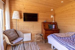 a bedroom with a bed and a tv and a chair at G195-Lemvig-Porsevej-95 in Lemvig