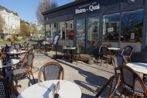 a row of tables and chairs in front of a restaurant at Hôtel de la Gare - Restaurant Bistro Quai in La Roche-sur-Yon