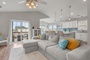 ein Wohnzimmer mit Sofa und eine Küche in der Unterkunft Sounds About Wright OBX in Kill Devil Hills