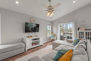 ein Wohnzimmer mit Sofa und Fernseher in der Unterkunft Sounds About Wright OBX in Kill Devil Hills