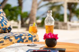 a bottle of wine and a glass on a table at Private Beach Front 2-Bedroom Apartment, Groundfloor in Kiwengwa
