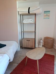 a bedroom with a bed and a table and a stool at Appartement Refait a neuf avec accès au jardin , local vélo et Wifi in La Machine