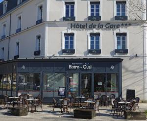 a group of tables and chairs in front of a building at Hôtel de la Gare - Restaurant Bistro Quai in La Roche-sur-Yon