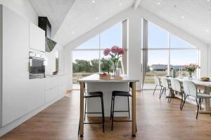 a white kitchen with a table and chairs at 373-Harboore-Slettevej-45 in Harboør