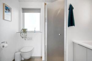 a white bathroom with a toilet and a window at 373-Harboore-Slettevej-45 in Harboør +20 photos