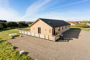 a house with a black roof on a gravel lot at 373-Harboore-Slettevej-45 in Harboør