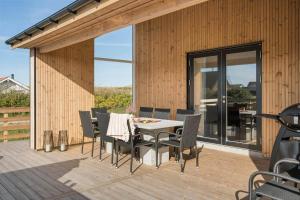 a patio with a table and chairs on a deck at 373-Harboore-Slettevej-45 in Harboør