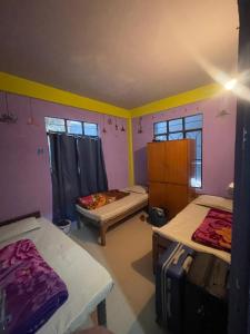 a room with two beds and two windows at Hazz Backpackers Hostel in Shillong