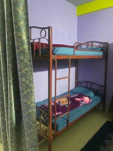 two bunk beds in a room with a curtain at Hazz Backpackers Hostel in Shillong +11 photos