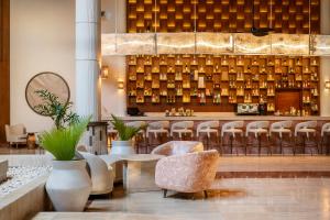 a lobby with chairs and a bar with lights at Grand Palladium Select Bávaro - All Inclusive in Punta Cana +135 photos