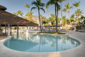 a swimming pool at a resort with palm trees at Grand Palladium Select Bávaro - All Inclusive in Punta Cana