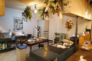 a large kitchen with a table and a counter top at すくもBOX guesthouse in Sukumo