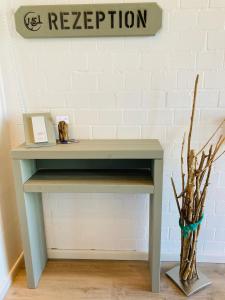 a gray console table with a sign on a wall at Hof Steinhütten in Westerhever