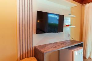 a flat screen tv hanging on a wall at Pedra do Sino Hotel in Piranhas