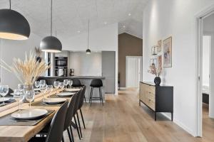 a dining room with a long table and chairs at 371-Harboore-Fourmivej-6 in Harboør