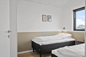 two beds in a room with a window at 371-Harboore-Fourmivej-6 in Harboør