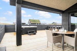 a patio with a table and chairs and a grill at 371-Harboore-Fourmivej-6 in Harboør