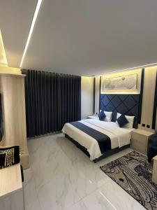 a bedroom with a large bed with a blue headboard at شقق فاخرة in Riyadh