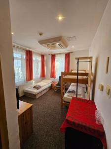 a bedroom with two bunk beds and a living room at Pension Zlata Noha in Bratislava