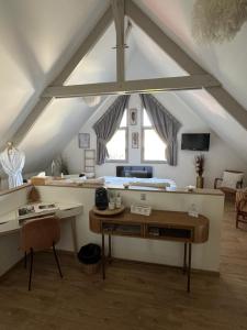 an attic room with a desk and a table at L'Orée du Mont proche du mont saint Michel in Pontorson
