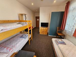 a room with two bunk beds and a television at Pension Zlata Noha in Bratislava
