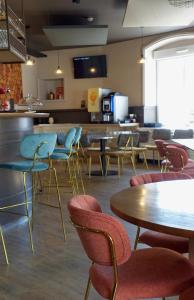 a restaurant with tables and chairs and a counter at Hôtel de la Gare - Restaurant Bistro Quai in La Roche-sur-Yon