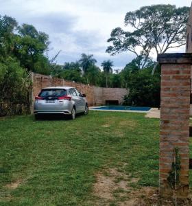 a car parked in a yard next to a brick wall at Cabaña Doña Adela in Paso de la Patria