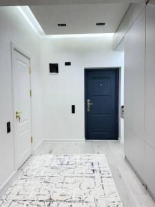 a blue door in a white room with a rug at Modern Luxury Apartment Central Samarkand in Samarkand