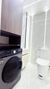 a bathroom with a washing machine and a toilet at Modern Luxury Apartment Central Samarkand in Samarkand