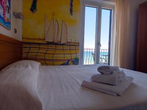 a bedroom with a white bed with towels on it at Villa Nettuno in San Menaio +15 photos