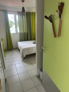a bedroom with a bed and a door to a room at Studio N10 Résidence OBAYEAR in Schœlcher