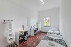 a dorm room with two beds and a desk and a computer at HI Aveiro – Pousada de Juventude in Aveiro