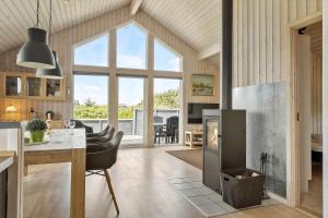 a kitchen and living room with a fireplace and a table at 374-Harboore-Fourmivej-15 in Harboør