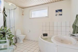 a bathroom with a tub and a toilet and a sink at 374-Harboore-Fourmivej-15 in Harboør +26 photos